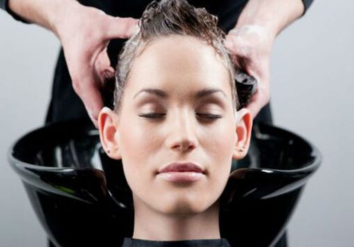 una ragazza si fa applicare il prodotto mentre si passa i capelli